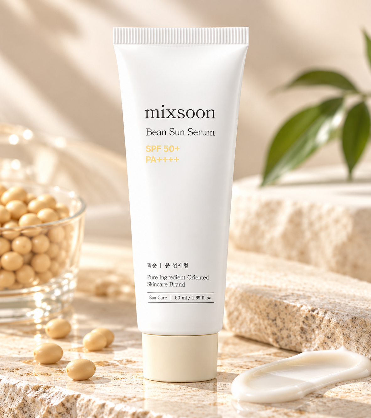 Mixsoon Bean Sun Serum SPF 50+ PA++++ 50ml Korean sunscreen displayed on natural beige stone with soybeans, green leaves and a smooth cream texture. An elegant K-beauty sun protection product composition featuring warm sunlight, soft neutral tones and a luxurious minimalist skincare aesthetic.